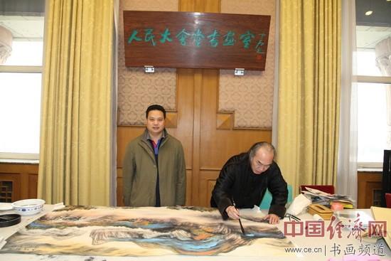 国画大家白雪狼(右)在现场作画,中国经济网书画频道名誉主编梁建忠(左)在现场。