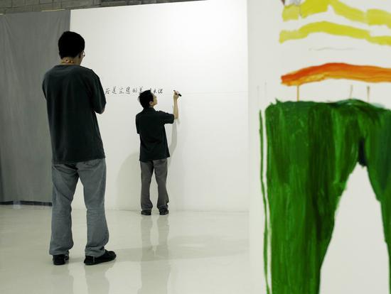2006年9月为《多米诺》展览在墙上写前言,刘小东为尹吉男画速写。