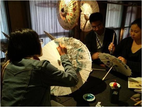 现场观众正在油纸伞上绘图