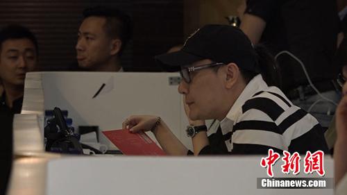张信哲头戴帽子,低调来到拍场,并在拍卖会场最后区落座。