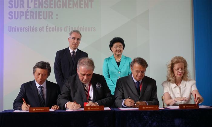 中国国务院副总理刘延东(右后)与法国教育部官员(左后)见证双方代表签署《中央美术学院中法艺术与设计管理学院合作协议》(前排左起:中央美术学院院长范迪安,巴黎第四大学(索邦大学)校长巴塞勒米·若贝尔,KEDGE商学院理事会主席弗朗索斯·皮尔逊,巴黎国立高等装饰艺术学院副院长米蕾耶•戴尔贝科