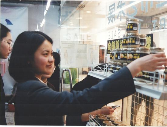 1999年4月10日“超市”展的第一天,一位观众正在拿起朱昱作品《全部知识学的基础》——一瓶死人脑汁做成的浆糊。