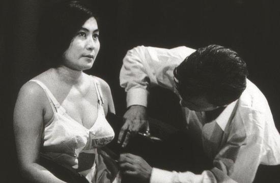 ▲ 小野洋子在纽约的Carnegie Hall的行为表演“Cut Piece”,1965年。 摄影:Minoru Niizuma