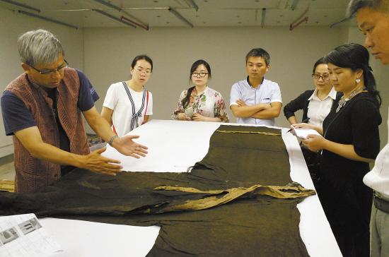 中国丝绸博物馆馆长赵丰(左一)在指导丝织品应急保护工作