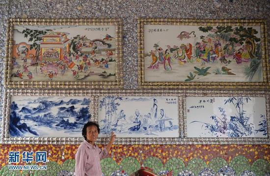 9月21日,余二妹在介绍“瓷宫”内的瓷板画。新华社记者 万象 摄 图片来源:新华网