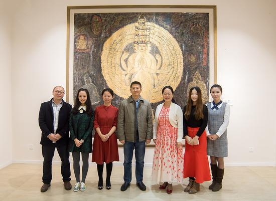 臧跃军(中)与西溪艺得美术馆工作人员在参展作品前合影