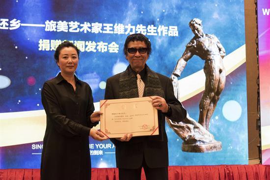 中国文化传媒集团副总经理、《艺术市场》杂志社股份有限公司董事长兼社长代柳梅 为王维力颁发收藏证书
