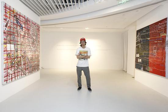 中国当代艺术家奶粉Zhou与作品合影