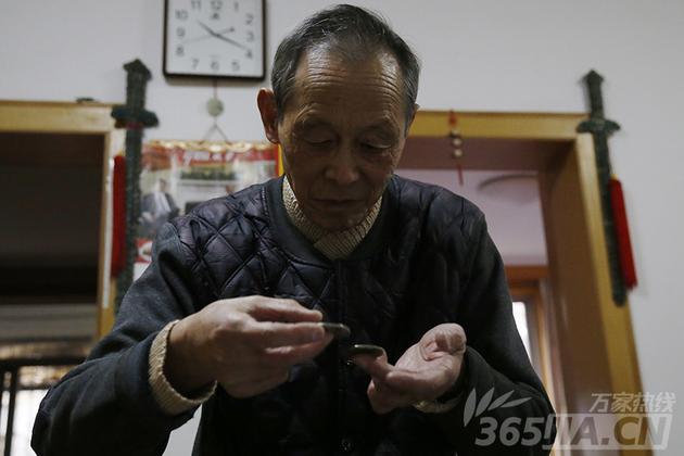 章克清老人拿着两枚“袁大头”,轻轻的碰一下就发出清脆的响声,老人说:“这是收藏钱币经常用到的手法:听音。”
