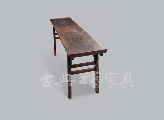 明 黄花梨骰柏楠面翘头案。《格古要论》楠木条中有“骰柏楠”一条曰“骰柏楠”木出西蜀马湖府,纹理纵横不直,中有山水、人物等花者价高。”此案面长205厘米米,宽50厘米,这样的尺寸非千年造化不可。