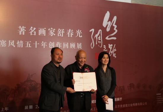 中华世纪坛艺术基金会的周围女士和赵长岭先生向舒春光先生颁发作品捐赠收藏证书