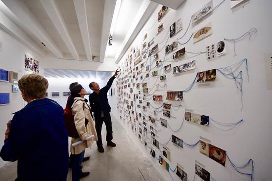 中国馆策展人邱志杰(右一)在展览现场向观众介绍中国馆内的艺术家师承(摄影:陈旖)