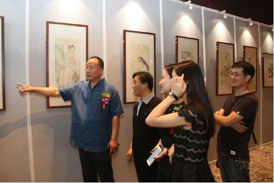 画展现场画家王根生给嘉宾讲解作品