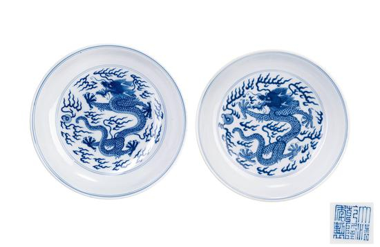 006 清乾隆 青花赶珠龙纹盘一对 本品圆口,浅弧腹,圈足。通体施素白釉,釉质莹润,胎薄质坚,盘心绘青花龙纹,碗外壁绘双龙赶珠纹,纹饰饱满,龙纹矫健,龙张口怒目,动感十足。青花发色纯正,釉面光润均匀。身体线条舒展劲健,须发、鳞片绘的一丝不苟,极为精细。底青花“大清乾隆年製”六字篆书款。此种样式的青花龙纹盘为清代官窑。 参阅:《形秀色丽四代珍》,大维德中国艺术基金会,1992 年。页146图166。 来源:伦敦苏富比1998;Lot205。 Qianlong Reign Period of Qing Dynasty, Blue-and-white pearl dragon vein plate; (a pair) D:17cm RMB: 100,000-150,000