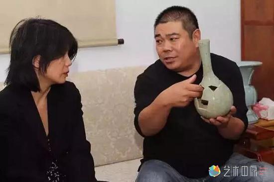 刘志军向梅美玲(左)介绍钧官窑作品相关知识。 牛书培 摄