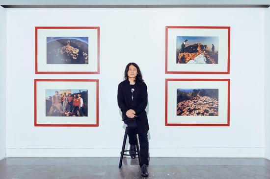 郑连杰在广东省美术馆接受采访,身后为该馆馆藏作品《大爆炸-捆扎丢失的灵魂》司马台长城系列作品(部分)