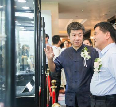 玉雕传承人张铁成(左)向李松平总经理(右)介绍作品