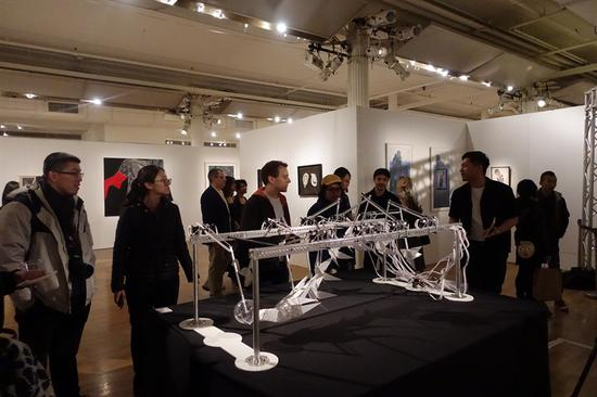“新青年:中美青年艺术展”参展艺术家朱峰毅(右三)向观众介绍作品《A Ritual that Lasts Forever》
