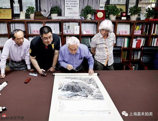 陆俨少大师的哲嗣陆亨先生(右二)正在鉴定《风流今见》专场作品