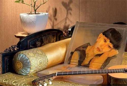 茶室一角,一张清末民初的楠木大漆床上摆着一幅喻红的自画像,吉他为西班牙手工名琴Amalio Burguet。