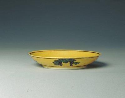 黄地紫绿龙葡萄纹碟,清光绪,高2.3cm,口径13cm,足径8cm。现藏故宫博物院。
