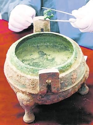 从战国“火锅”铜鼎中夹出一块动物骨头
