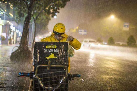 在大雨中送餐的外卖骑手