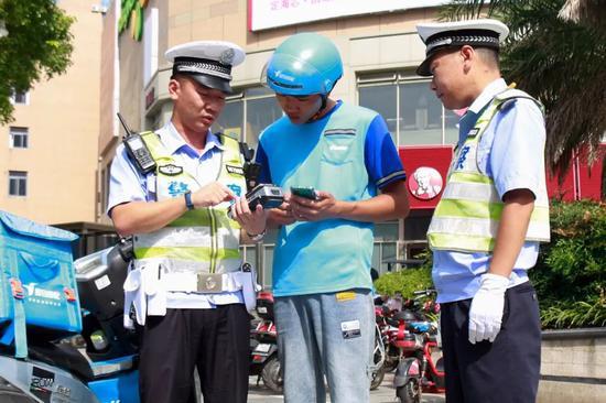 民警向骑手讲解DS骑手记分小程序的使用方法
