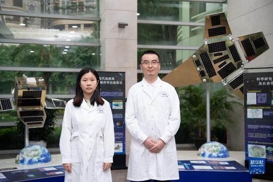 5月24日,澳科大月球与行星科学国家重点实验室博士后研究员尹亮(右)、澳科大太空科学研究所硕士研究生易思琦在澳门科技大学合影。新华社记者 张金加 摄