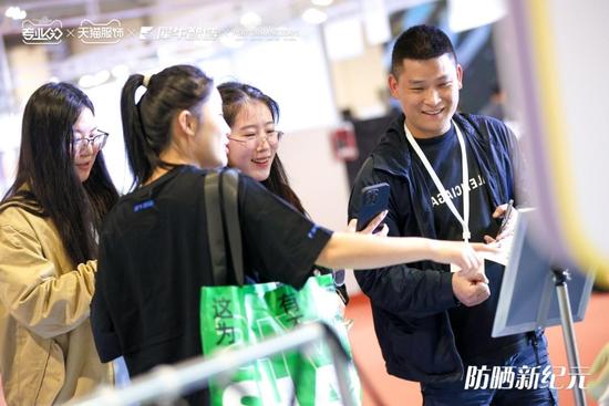 图片说明:在上海世博展览馆,消费者在兴致勃勃地了解今年的防晒服流行趋势
