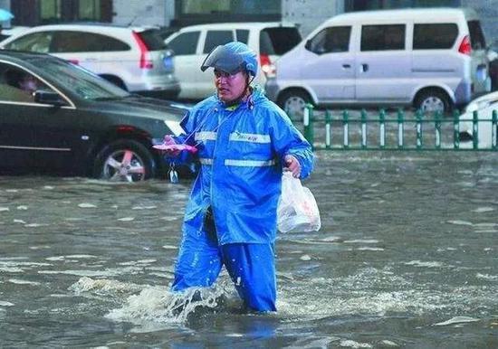 外卖小哥在暴雨中涉水而行