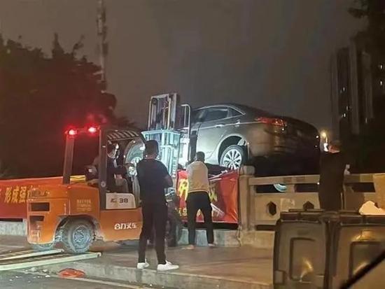 叉车将轿车扔进河道。(图/网络)
