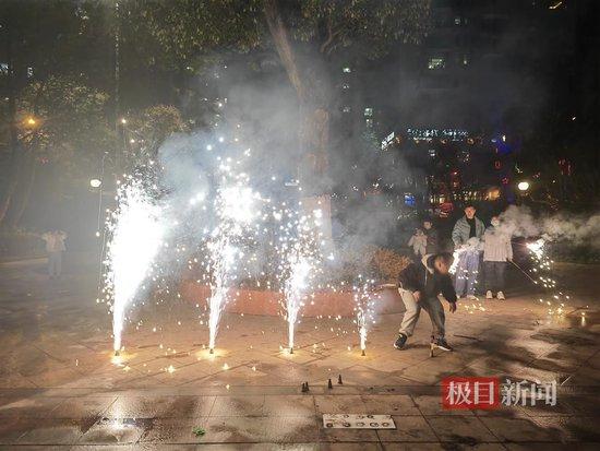 1月1日晚,在浏阳河畔广场上放烟花的市民