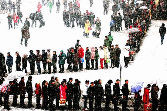 2007年2月7日,一场暴雪突降太原市,在太原站购买车票的人们排成了长龙。视觉中国供图