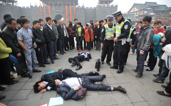 2010年11月8日下午,重庆九龙坡区巴国城,三名喝醉的年轻人倒在广场。据悉,他们是来参加某公司招聘销售人员的复试,中午领导请吃饭,他们拼命喝酒争表现醉了。/CFP