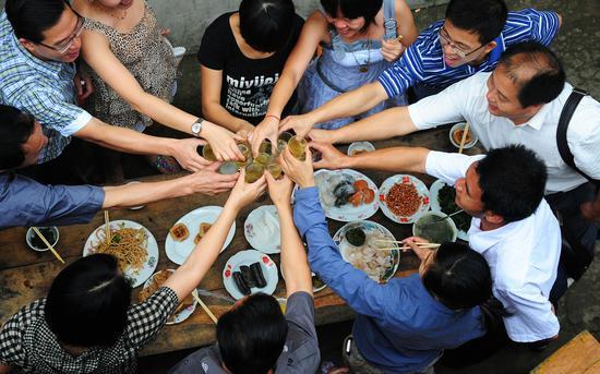 2010年5月23日,广西防城港市防城区那良镇,众人在当地举办的百家宴上互相敬酒。/CFP