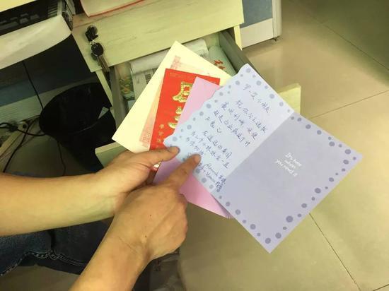 罗尔向记者展示人们送给笑笑的贺卡。图 / 卫诗婕