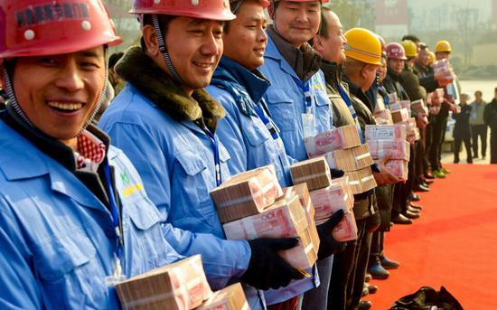 2016年1月,河南一房地产项目工地上,开发商摆了2000万元现金,现场为农民工发放工资。