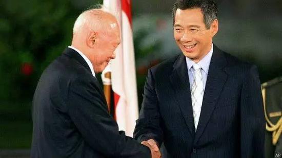 2004年8月12日,李光耀在儿子李显龙宣誓就任新加坡总理后上前祝贺。(网络图)
