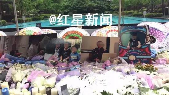 事发小区内摆放着死者生前的照片进行祭奠:死者是一位母亲和她的三个孩子