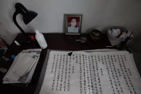 ▲2017年7月17日,赵菁家中的写字台上,摆放着母亲的遗照和书法习作。这一年来,她经常通过练习书法的方式平复自己的情绪,同时消磨在家修养的时间。