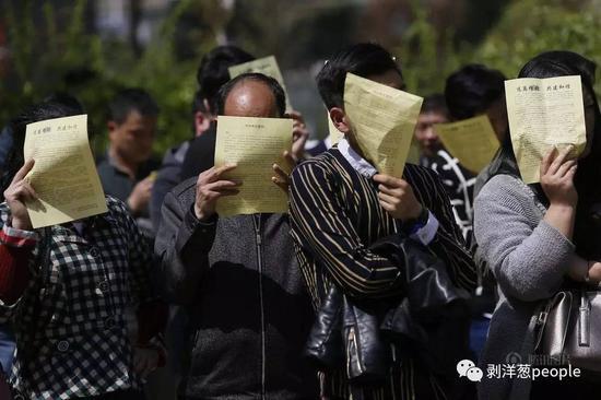 民众在阅读“远离传销,共建和谐”宣传单。
