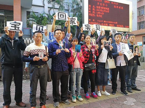 2017年11月2日,庭审之前,9名被拐孩子的家人合影,渴望“宝贝回家”。 澎湃闻闻记者 朱远祥 图