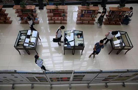 几名大学生在西南大学图书馆参观重庆地方志展览。来源:视觉中国 资料