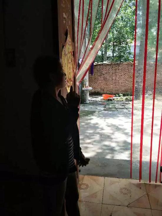 5月26日,杨美芹一边和记者讲话一边呆呆地望着门外。