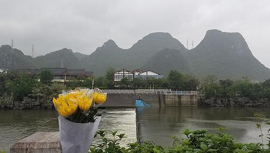 桃花江鲁家村水域的滚水坝。公路大桥上有人摆上纪念遇难者的菊花。摄影:翟星理