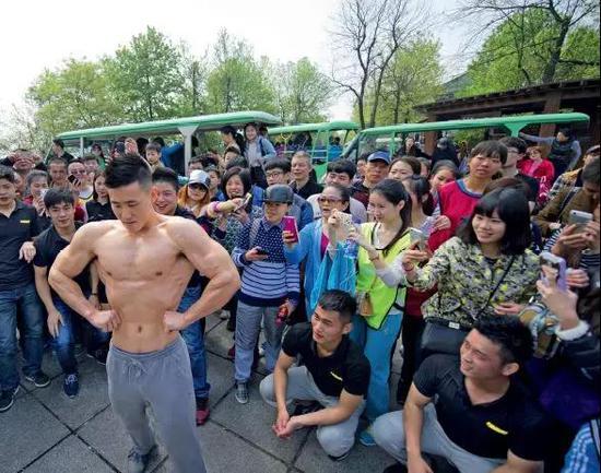 2015年4月11日,长沙一家健身俱乐部的健身教练与市民在岳麓山进行了一场平板支撑挑战赛,肌肉健硕的健身教练刚一亮相就引起了众多女性的尖叫。图/视觉中国