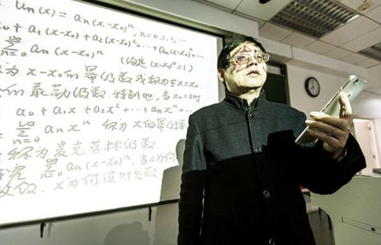 3月23日,浙大紫金港校区东教学楼,微积分课上,苏德矿拿着手机给学生们讲解。