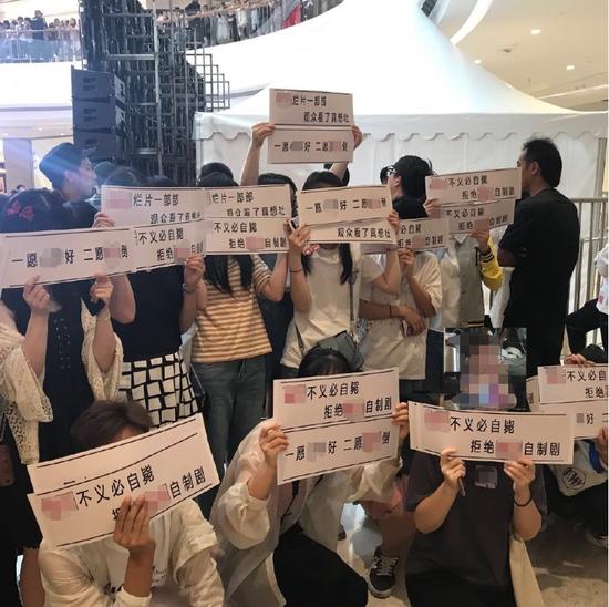 在某活动现场,粉丝举牌抵制艺人经纪团队。图片来自网络