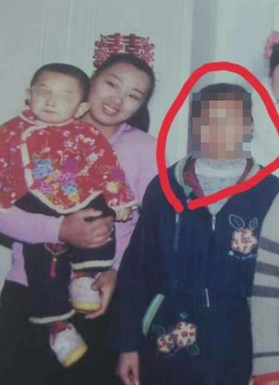 2006年春天,万秀玲(左)抱着小儿子与女儿汤兰兰(右)合影。